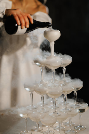 Glittering champagne flows between crystal cupsの写真素材