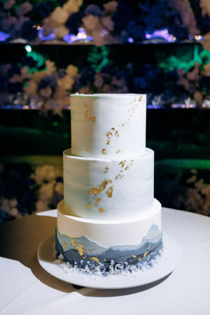 Stylish white cake with gold accents and marble details