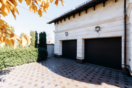 elegant driveway setting, classy garage entrance surrounded by manicured greenery and artisticの写真素材