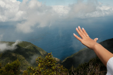 Open hand signals invitation to explore distant cloudcoveredの写真素材