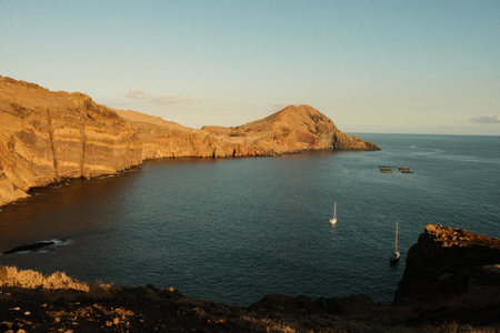 Serene bay with rugged cliffs illuminated during sunset