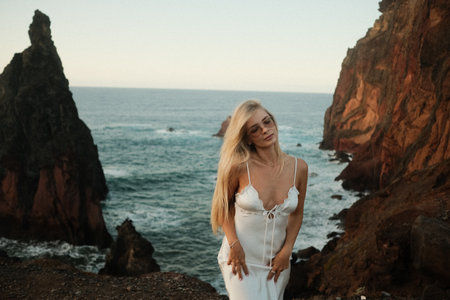 Chic blonde model by rugged shoreline showcasing dramaticの写真素材