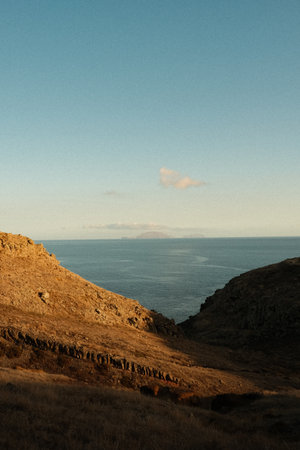 Gentle hillside at dusk casting long shadows over tranquil blueの写真素材