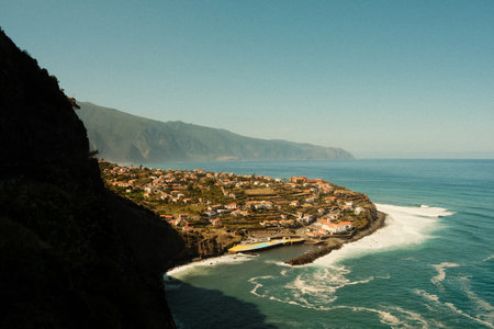 Rugged cliff town nestled along shimmering ocean shoresの写真素材