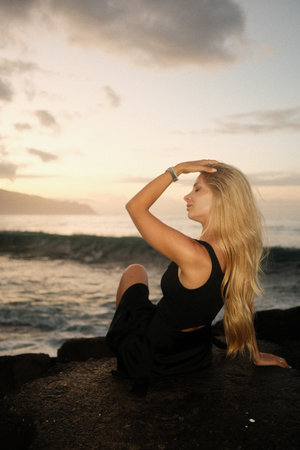 Serene ocean scene capturing feminine elegance during golden glowの写真素材