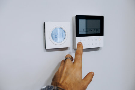 User interacts with touch interface on modern HVAC digital deviceの写真素材