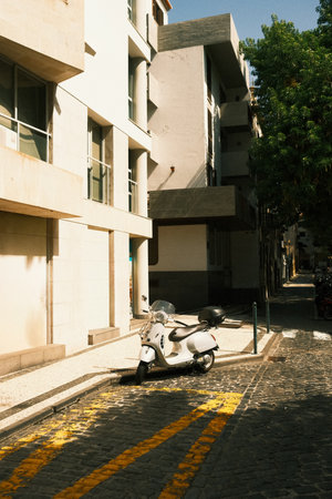 Quiet urban morning featuring sleek white moped and texturedの写真素材