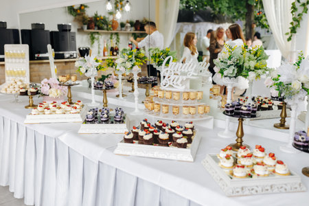 Stylish confectionery arrangement beside floral decorationsの写真素材