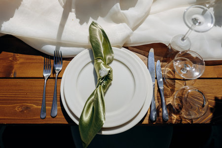 Minimalist tableware featuring delicate cutlery and satin napkin