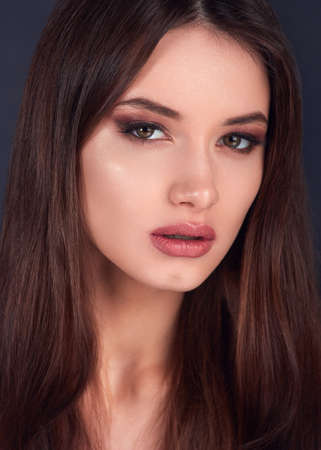 Young woman with beautiful healthy face with pink lipstick and pink manicure.Beautiful young woman with clean skin of the face.の写真素材