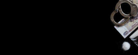 Handcuffs on a bundle of ruble banknotes (Russion money) and cocaine, black background. Long bannerの写真素材