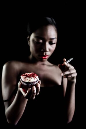 A young model with cupcake, photographed in the studio.の写真素材