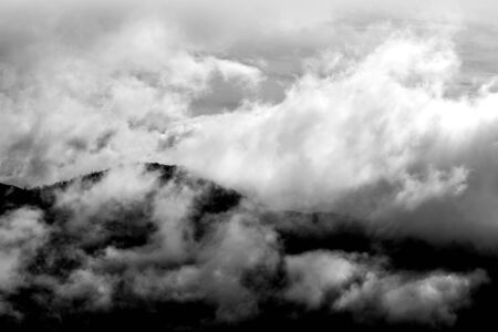 Clouds over mountain ranges with tressの写真素材