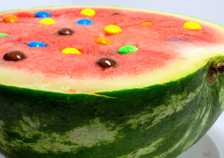 half of red watermelon with colored candy. isolated fruit.の写真素材