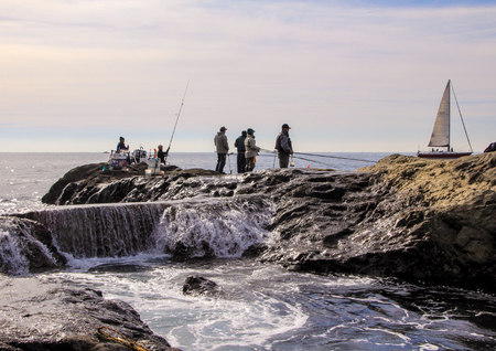 Fishermen and yaht on the rocks in the Pacific Ocean. Nature of Japan. Kamakura, Japan, 01/06/2013.のeditorial素材