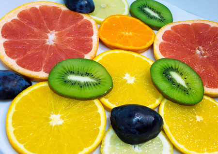 Colorful of cut fruits close up. Vegetarian food on the plate.の写真素材
