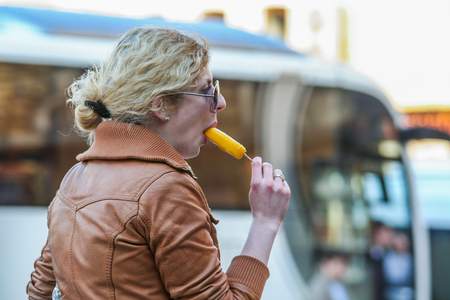 2010.04.11, Moscow, Russia. Side view of a woman eating fruit ice cream outside.のeditorial素材