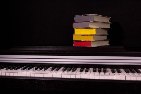 stack of colored books on a black background. Concept of education and reading.の写真素材