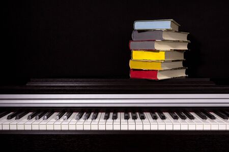 stack of colored books on a black background. Concept of education and reading.の写真素材