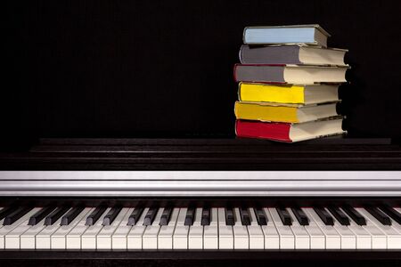 stack of colored books on a black background. Concept of education and reading.の写真素材