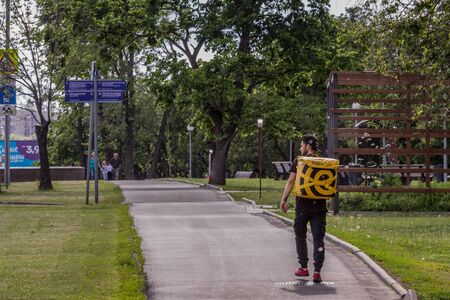 Food delivery man going down the street. delivery service.のeditorial素材