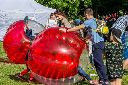 2019.06.01, Moscow, Russia. Entertainment of zorbing in the park. Children rolling downhill inside an orb (sphere). Enjoy of childhood.のeditorial素材