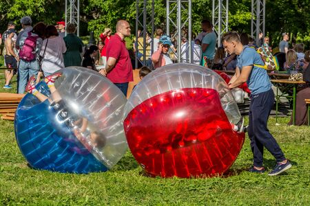 2019.06.01, Moscow, Russia. Entertainment of zorbing in the park. Children rolling downhill inside an orb (sphere). Enjoy of childhood.のeditorial素材