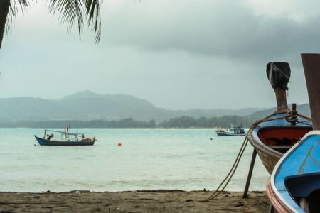 05/05/07, Phuket, Thailand. Travel around Asia. Boat on the sand by palm trees and on the waves.