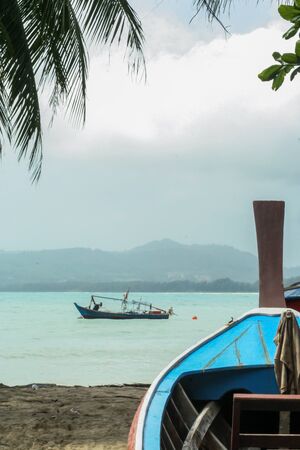05/05/07, Phuket, Thailand. Travel around Asia. Boat on the sand by palm trees and on the waves.