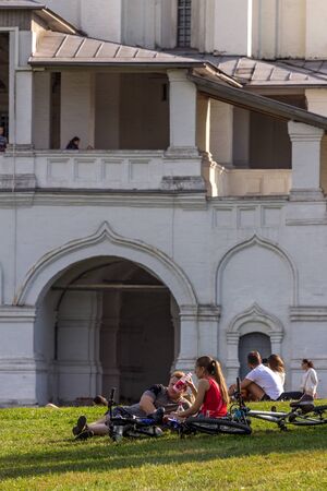 2019.09.01, Moscow, Russia. tourists relax in the shade of a tree in Kolomenskoye park on the background of an old church, from UNESCO World Heritage.のeditorial素材