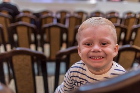 2019.05.10, Tula, Russia. Portrait of a little smiling boy sitting on the chair and looking to camera.の写真素材