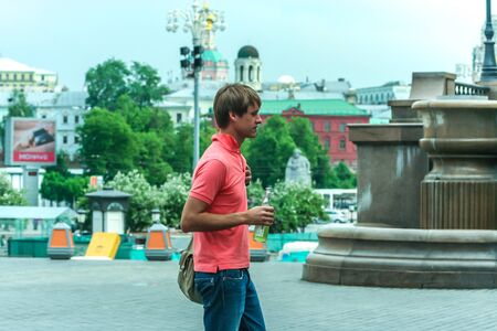 2011.05.21, Moscow, Russia. A single young man wearing pink polo having fun by the square, side view.のeditorial素材