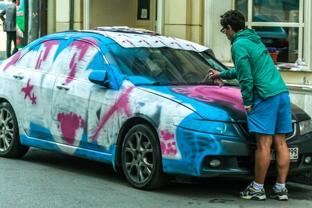 2011.05.21, Moscow, Russia. A young man carefully takes care of his car, painted with airbrushing.のeditorial素材