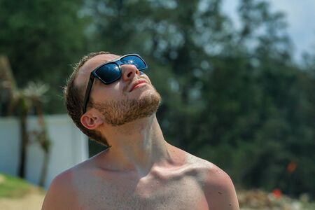 young handsome bearded guy in black sunglasses close up, looking upの写真素材