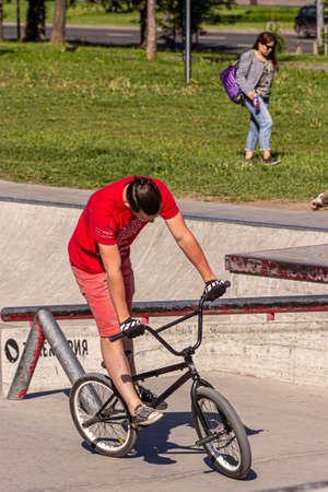 05/26/2018, Moscow, Russia. A teenager boy in a red t-shirt does tricks on a special bike at a skatepark. Active lifestyle of modern russian children.のeditorial素材
