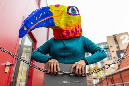 Masked woman - brightly colored bird head with a large beak. homemade original costume for the holiday. woman depicts a bird.の写真素材