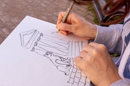 girl draws a picture with watercolor paints, close up. drawing on the open air.