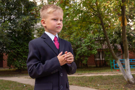 Portrait of a blond boy wearing a classic suit, looking away. First grader going to go to school.の写真素材