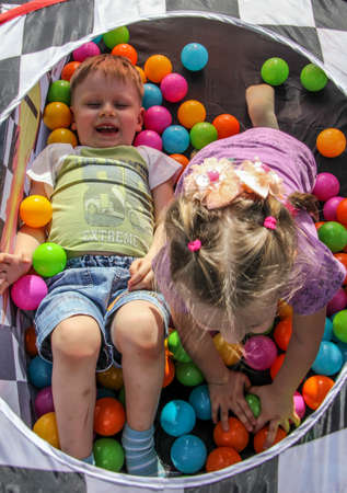 04/29/2012, Maloyaroslavets, Russia. A boy and girl lying among the colorful balls. A kids playing on the open air.のeditorial素材