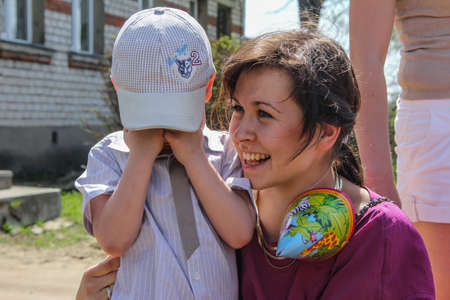04/29/2012, Maloyaroslavets, Russia. young woman laughs cheering her crying son. Young family emotions.のeditorial素材