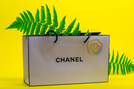 08.10.2020, Moscow, Russia. White Chanel bag and fern leaves on yellow background.のeditorial素材