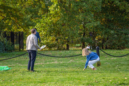 09/27/2020, Moscow, Russia. A young man and woman play badminton outdoors in autumn park.のeditorial素材