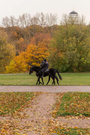 11.10.2020, Moscow, Russia. Police officers riding horse on background of falling trees. Travel around Moscow.のeditorial素材