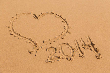 heart drawn in the sand on the beach 2014 yearの写真素材