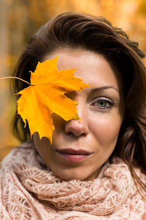 face woman with yellow leafの写真素材