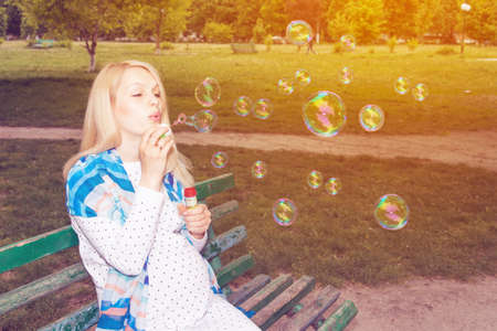 Pregnant park blowing bubbles benchの写真素材