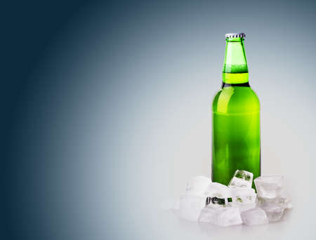 beer bottle in ice cubes on blue backgroundの写真素材