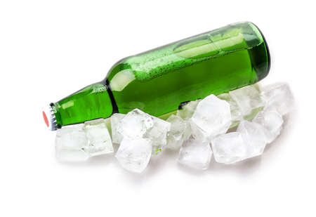 beer bottle in ice cubes isolated on white backgroundの写真素材
