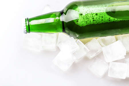 beer bottle in ice cubes isolated on white backgroundの写真素材
