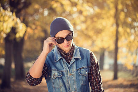 portrait of a man with sunglasses autumn parkの写真素材